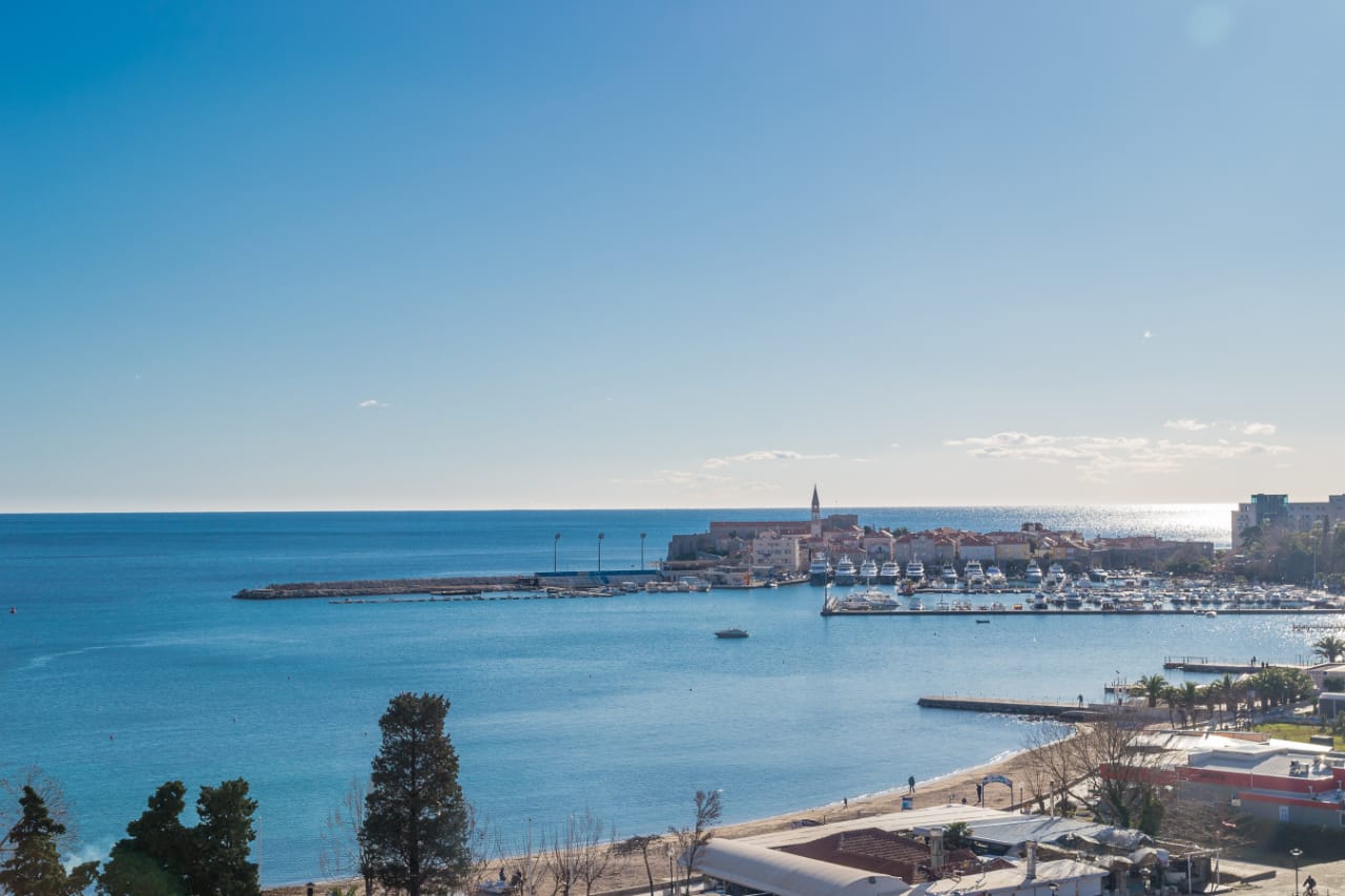 Panoramablick auf das Meer, den Strand und die Altstadt von Budva mit dem Yachthafen, Montenegro.