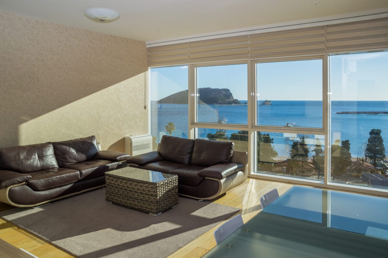 Wohnzimmer mit Ledersofas und Panoramablick auf das Meer in einer Wohnung in Budva, Montenegro.