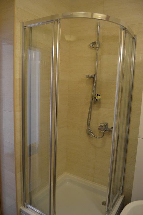 Modern shower cabin with chrome mixer in the bathroom of an apartment in Bečići, Montenegro.