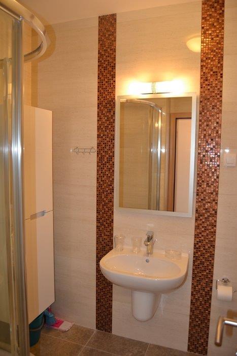 Modern bathroom with shower cabin in an apartment, Becici, Montenegro: beige tiles and mosaic decor.