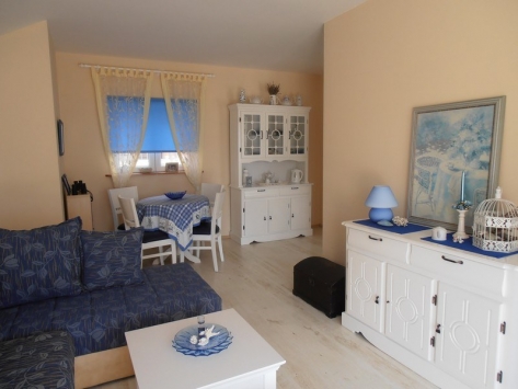 Gemütliches Wohnzimmer mit weißen Möbeln und blauen Textilien in einer Villa in Luštica, Montenegro: helles Interieur, Essbereich.