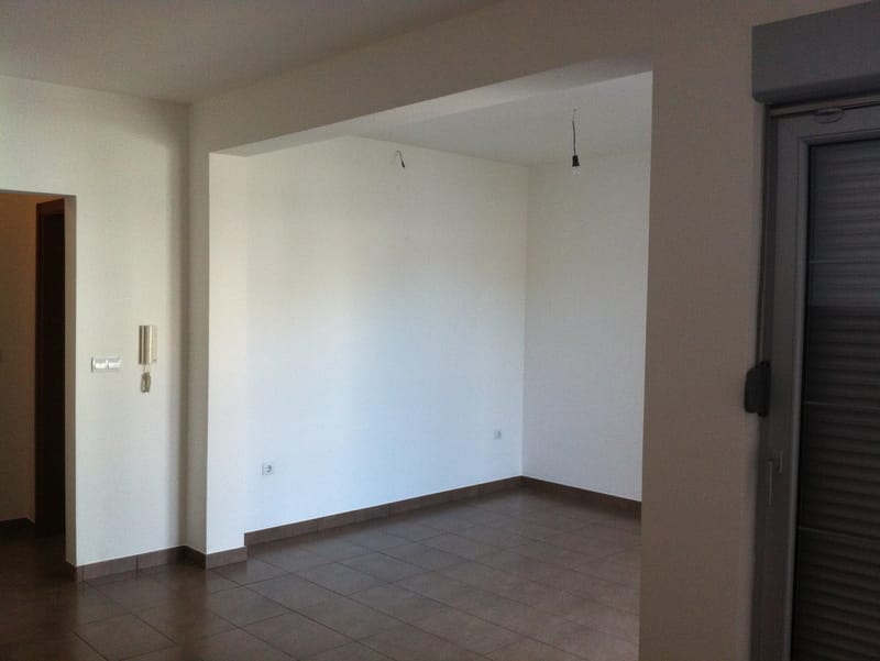 Helles Wohnzimmer mit Fliesen in einer neuen Wohnung in Petrovac, Montenegro: bezugsfertige Ausstattung, Zugang zum Balkon, Innenansicht.