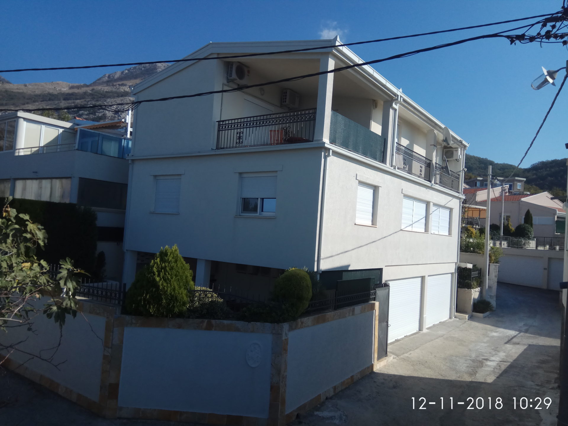 Vue extérieure d'un immeuble résidentiel à plusieurs étages avec façade blanche et balcons.