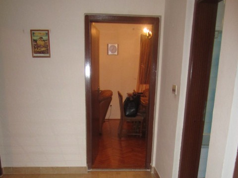 Blick vom Flur ins Wohnzimmer mit Parkettboden und Möbeln in einem Haus zum Verkauf in Tivat, Montenegro.
