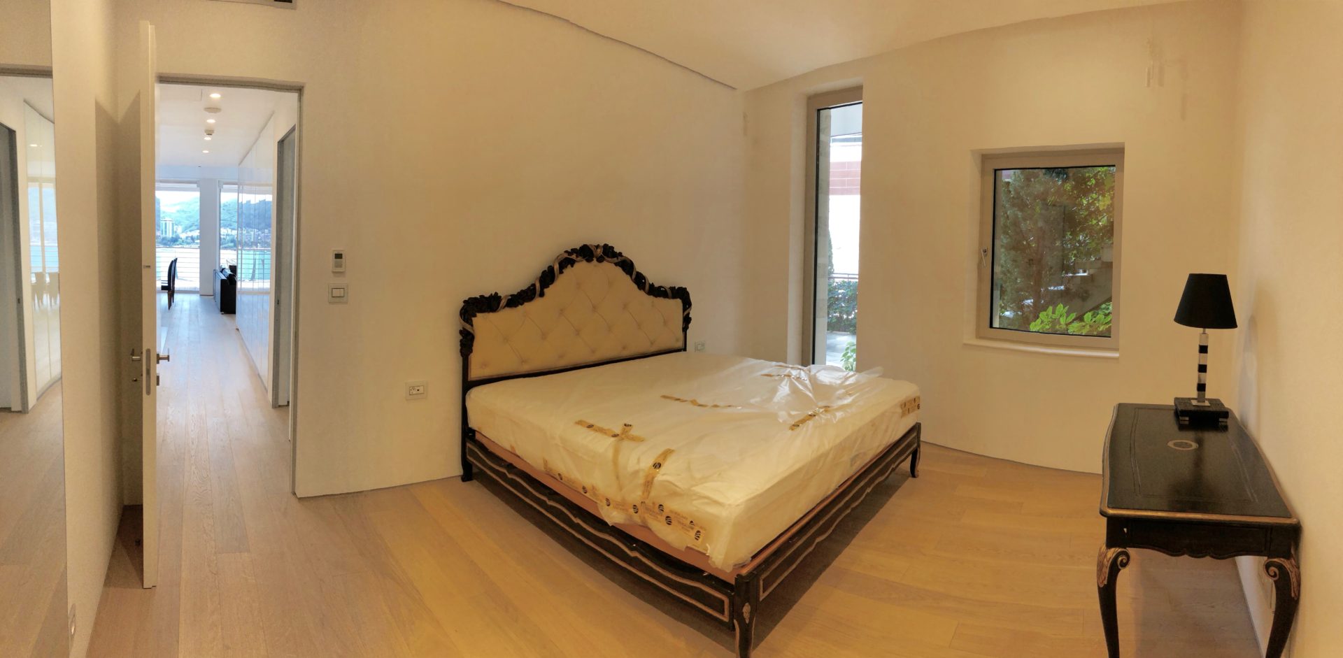 Schlafzimmer in einer modernen Wohnung in Budva, Montenegro: Doppelbett mit gepolstertem Kopfteil und Meerblick.