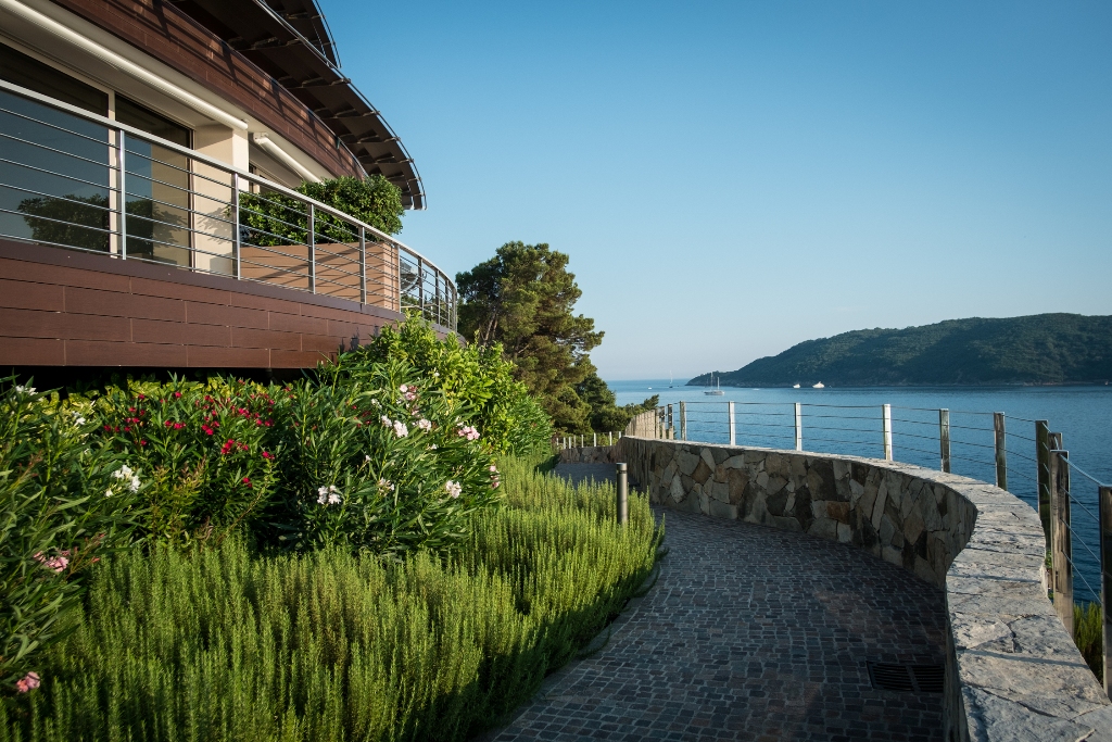 Moderne Villa in Budva, Montenegro: Terrasse mit Meerblick, Steinweg und Landschaftsgestaltung mit Blumen.