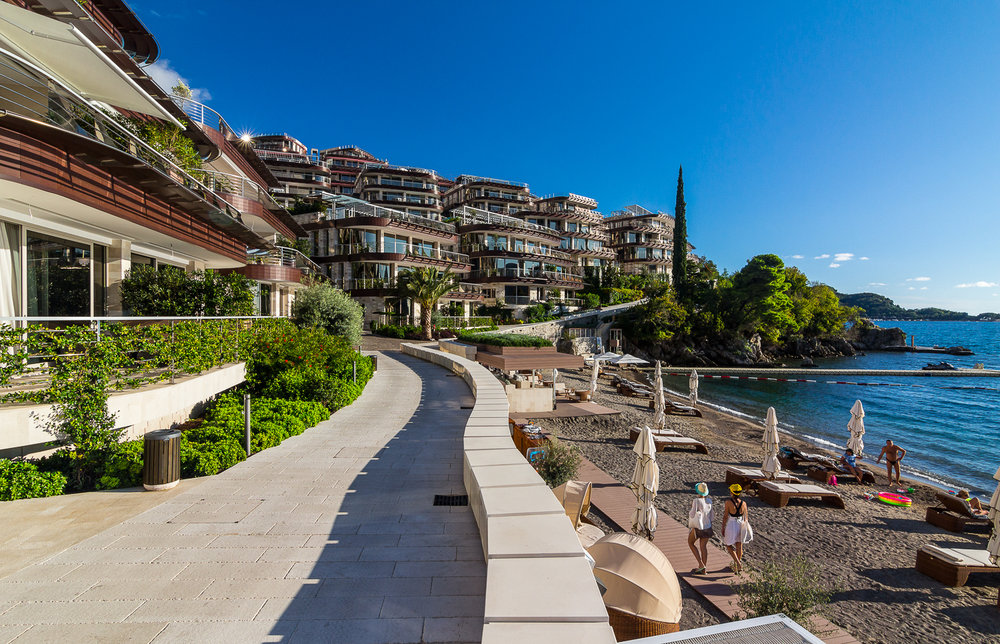 Moderner Wohnkomplex am Meer mit Privatstrand und Terrassen in Budva, Montenegro: Blick auf die Küste und die Apartments.