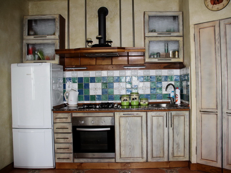 Rustic-style kitchen with wooden fronts in a house in Dobri Vody, Montenegro: built-in appliances and tile.