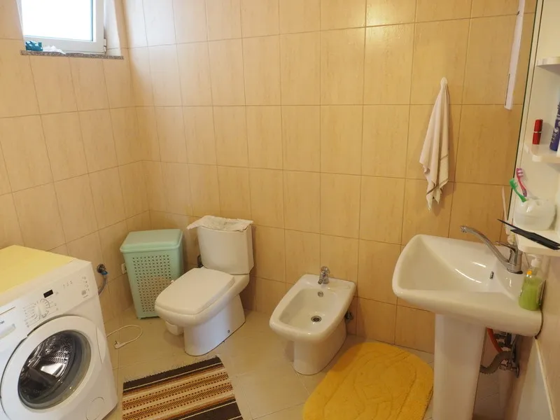 Kupatilo sa belom sanitarnom opremom, bideom i veš mašinom u kući u gradu Bar, Crna Gora.