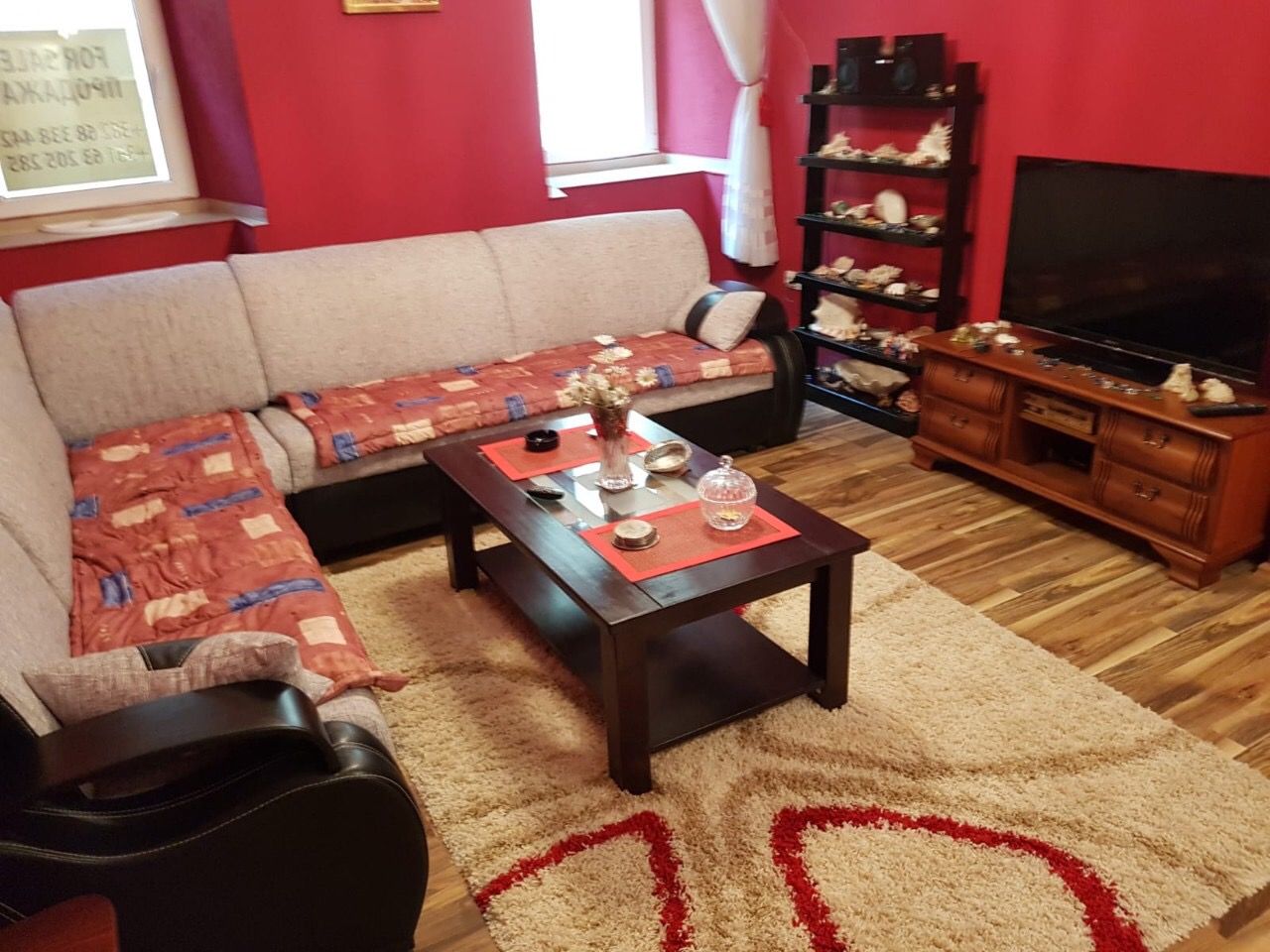 Gemütliches Wohnzimmer mit Ecksofa, TV-Bereich und hellem Interieur in einer zum Verkauf stehenden Wohnung, Budva, Montenegro.