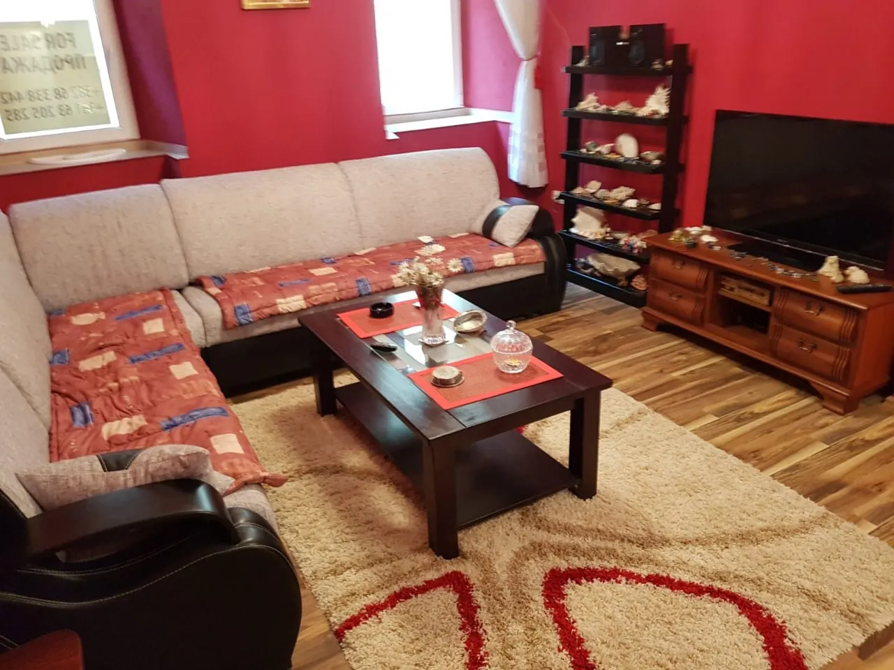 Satılık dairede köşe koltuklu, TV alanlı ve canlı dekorlu уютный oturma odası, Budva, Karadağ.