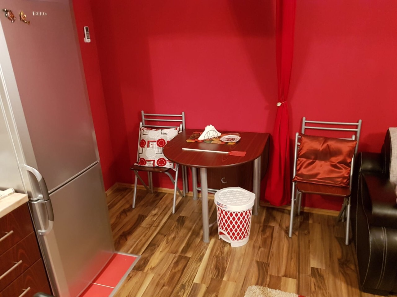 Küche in einer Wohnung in Budva, Montenegro: Essbereich mit Holztisch, Stühlen und Kühlschrank im Innenraum.