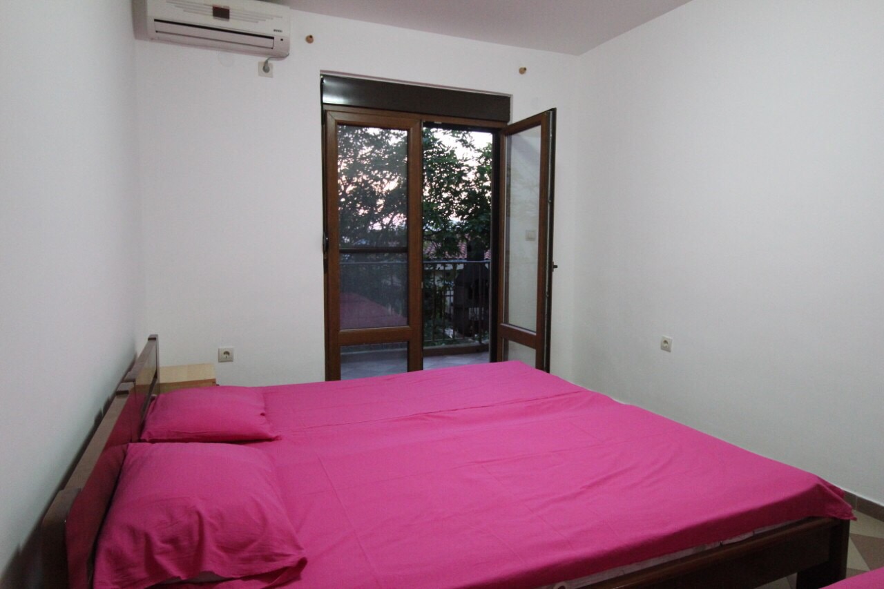 Schlafzimmer mit Doppelbett und Zugang zum Balkon im Haus, Dobri Vody, Barska Riviera, Montenegro.