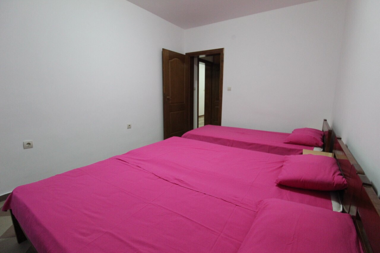 Schlafzimmer mit zwei Betten und rosa Bettwäsche in einem Haus an der Bar Riviera, Montenegro.