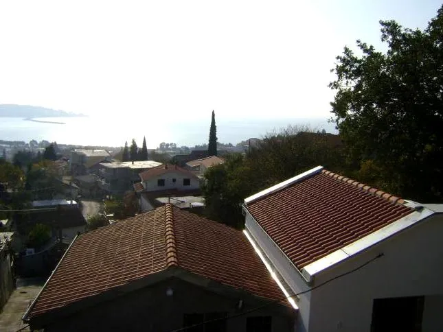 Pogled na more i grad Šušanj u Crnoj Gori sa terase kuće sa krovom od crepova, okružene zelenilom i privatnom gradnjom