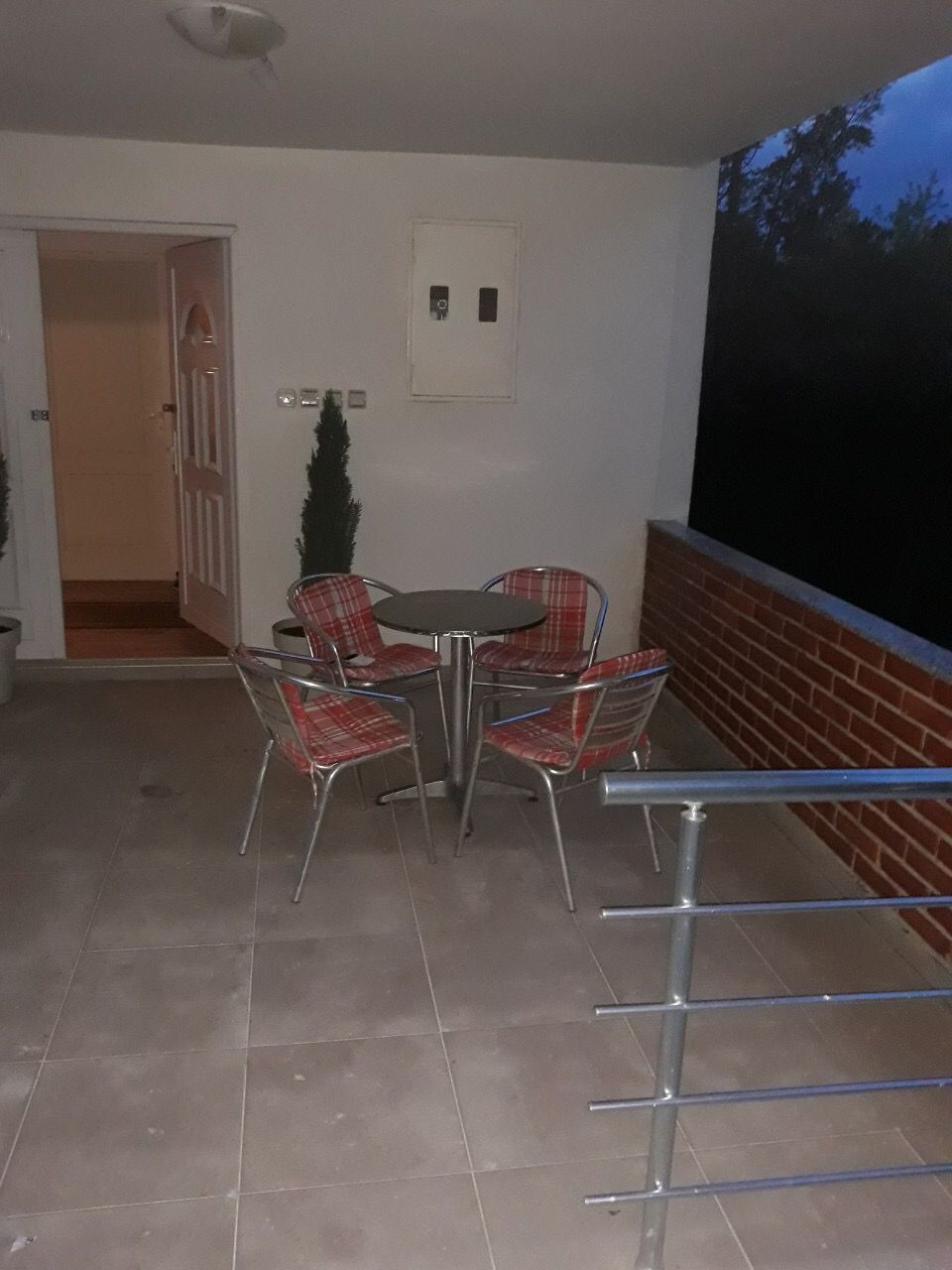 Przytulny taras z jadalnią i ceglanym ogrodzeniem w domu w kurorcie Žanjice, Czarnogóra.
