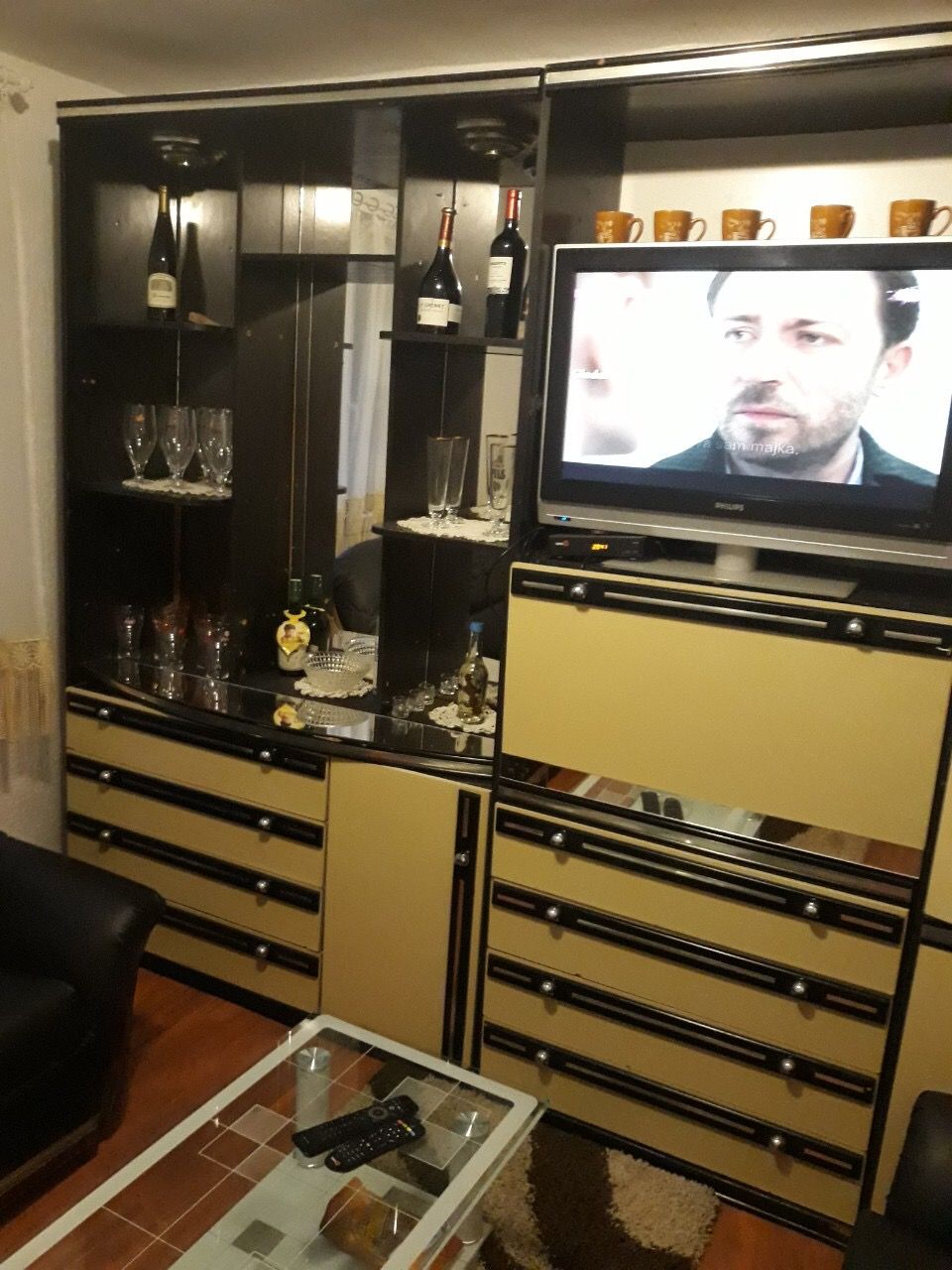 Salon w domu w Žanjicach, Czarnogóra: meblościanka z witryną, telewizor i stolik kawowy we wnętrzu.
