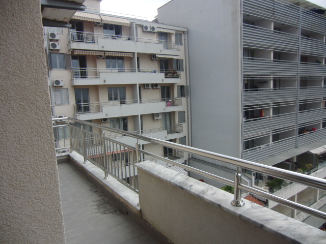 Geräumiger Balkon mit Metallgeländer in einer Wohnanlage, Blick auf die Nachbarhäuser in Budva, Montenegro.
