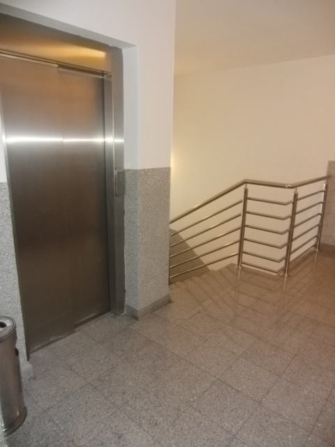 Moderner Aufzug und Treppenabsatz mit Steinverkleidung in einer Wohnanlage in Budva, Montenegro.