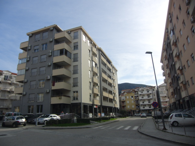 Modernes Mehrfamilienwohnhaus mit Balkonen und Parkplatz in Budva, Montenegro. Blick auf die Fassade des Gebäudes.