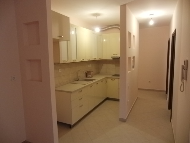 Moderne helle Küche in einer Wohnung in Budva, Montenegro: Hochglanzküche, Einbaugeräte und Wandnischen.