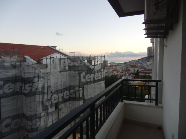 Blick vom Balkon der Wohnung in Budva, Montenegro: Stadtpanorama, Meereshorizont und Nachbargebäude mit Baugerüst.