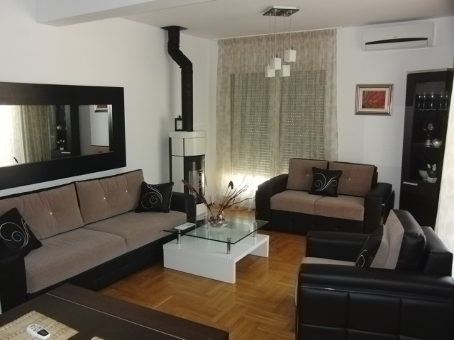 Wohnzimmer in einer Wohnung in Budva, Montenegro: moderne Möbel, Kamin, Parkettboden und Klimaanlage im Interieur.
