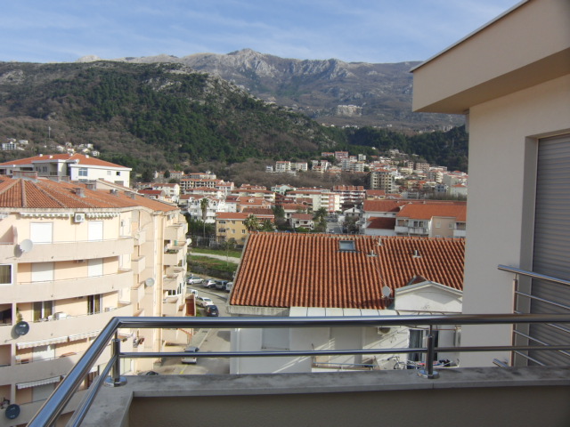 Blick vom Balkon der Wohnung in Budva, Montenegro: Panorama der Stadt mit Ziegeldächern und Berglandschaft im Hintergrund.