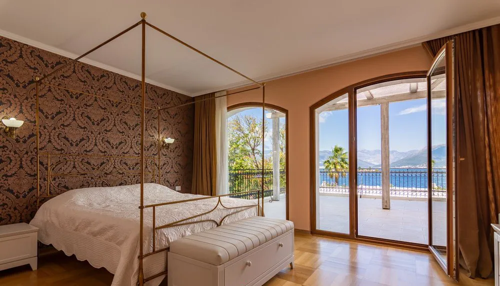 Bedroom with a canopy bed and sea view in a villa in Krašići, Montenegro: stylish interior and terrace.