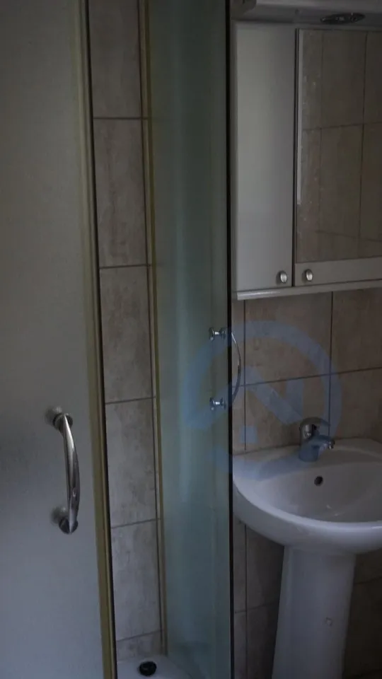 Bathroom with shower cabin and sink in a house, Kavac, Montenegro: modern tile finish and mirror.