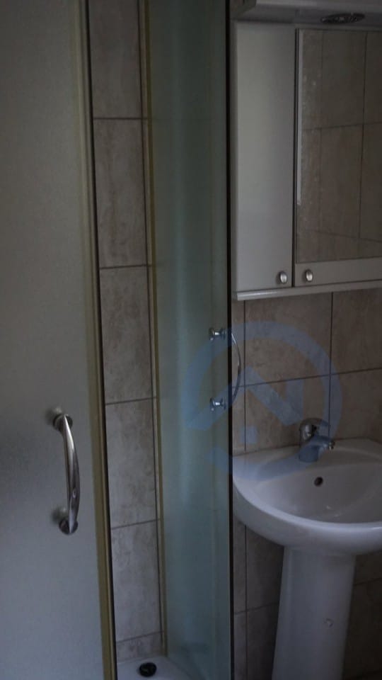 Kupatilo sa tuš kabinom i umivaonikom u kući, Kavač, Crna Gora: moderna obloga od pločica i ogledalo.