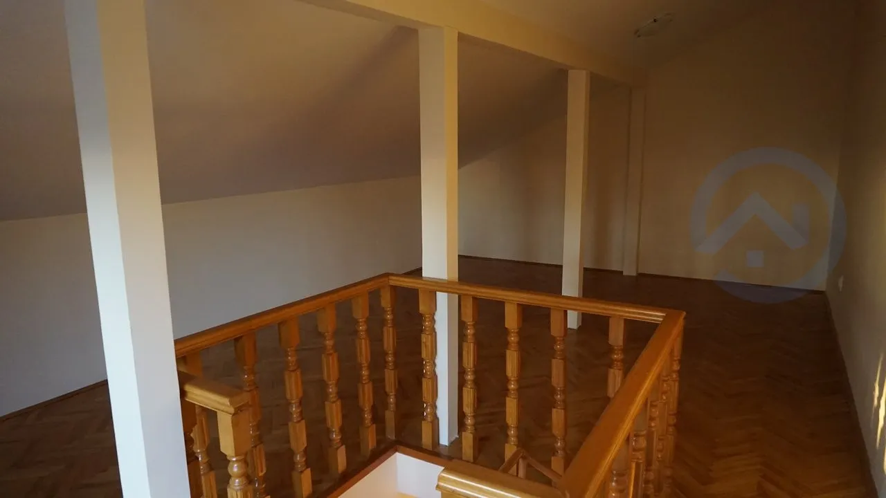 Spacious attic room with wooden parquet flooring and a staircase in a house, Kavac, Montenegro.