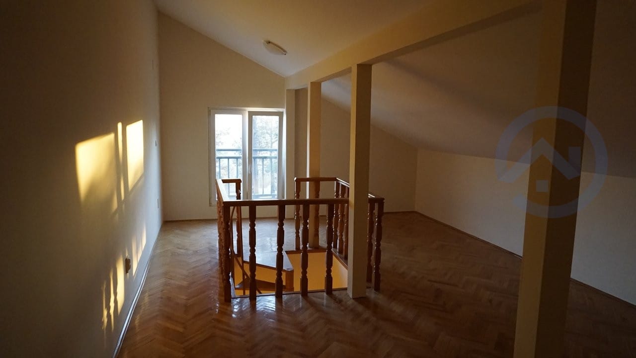 Potkrovlje dnevna soba sa parketom i drvenim stepeništem u kući, Kavač, Crna Gora. Svetla soba sa izlazom na balkon.