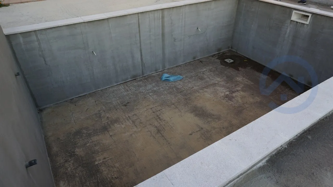 Concrete pool under construction on a house plot in Kavac, Montenegro: view of the pool basin during finishing.