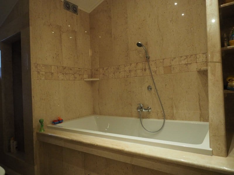 Kupatilo sa završnom obradom od bež mermera u vili, Stoliv, Crna Gora: ugradna kada i kvalitetna renovacija.