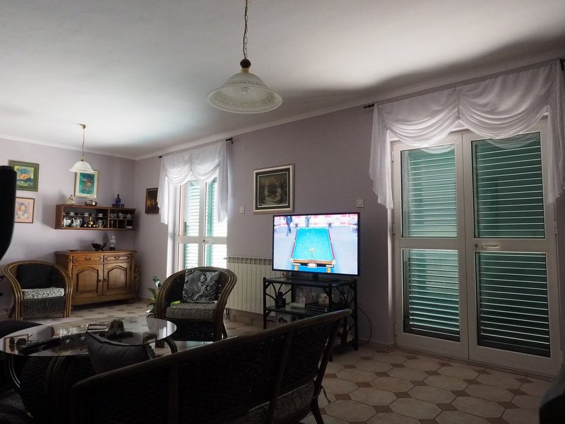 Gemütliches Wohnzimmer mit Rattanmöbeln und Zugang zur Terrasse in einer Villa, Stadt Dobrota, Montenegro.