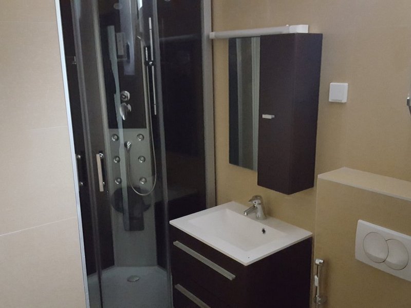Modernes Badezimmer mit Duschkabine und Waschtischunterschrank in einer Wohnung, Stadt Dobrota, Montenegro.