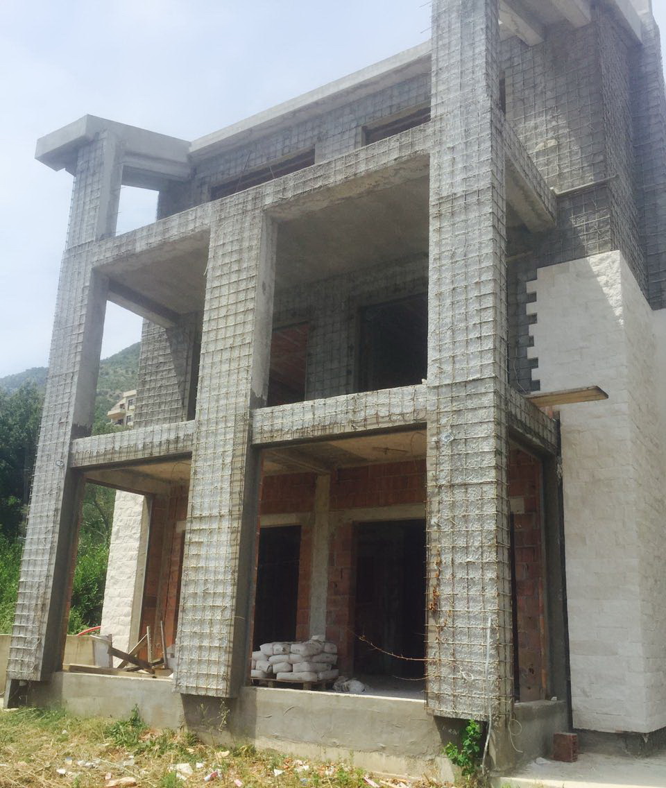 Im Bau befindliche Villa in Herceg Novi, Montenegro: monolithischer Gebäuderahmen mit teilweiser Steinverkleidung und Terrassen.
