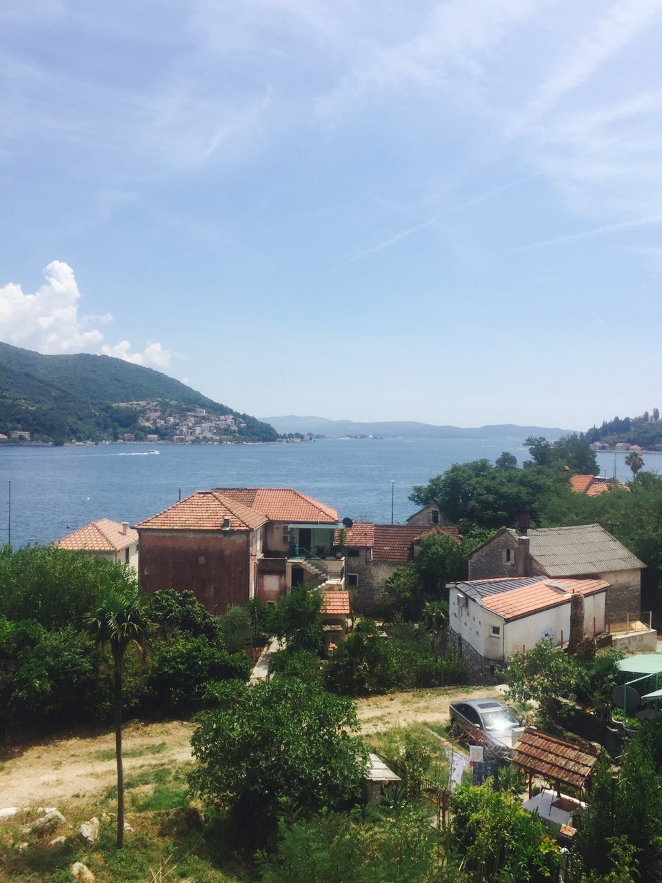 Panoramablick auf Meer und Berge von der Villa in Herceg Novi, Montenegro: Ziegeldächer, Grün und Meeresbucht.