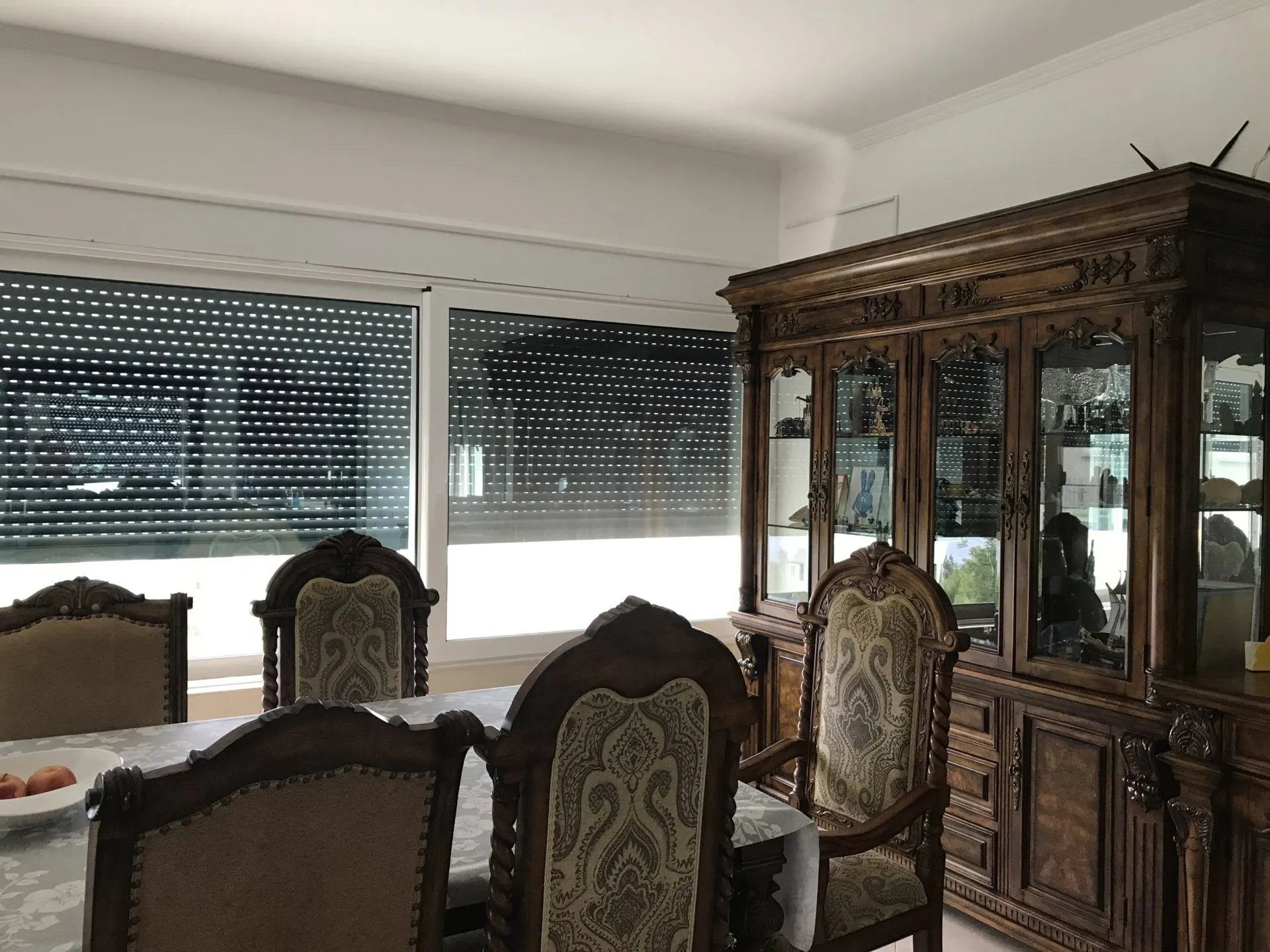 Klasična trpezarija sa rezbarenim drvenim kredencem i stolicama u kući na prodaju, grad Bar, Crna Gora.