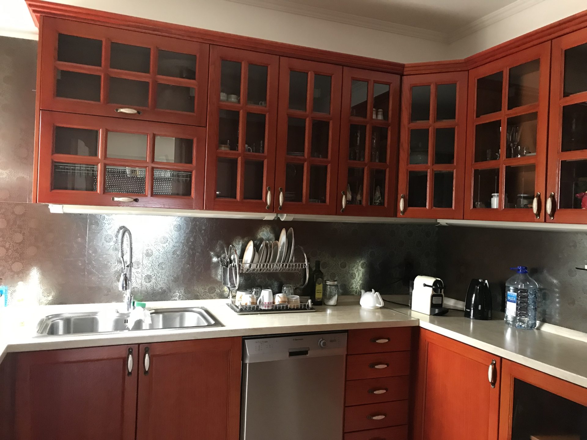 Eckküche mit Holzfronten und Einbaugeräten in einem Haus zum Verkauf, Stadt Bar, Montenegro.