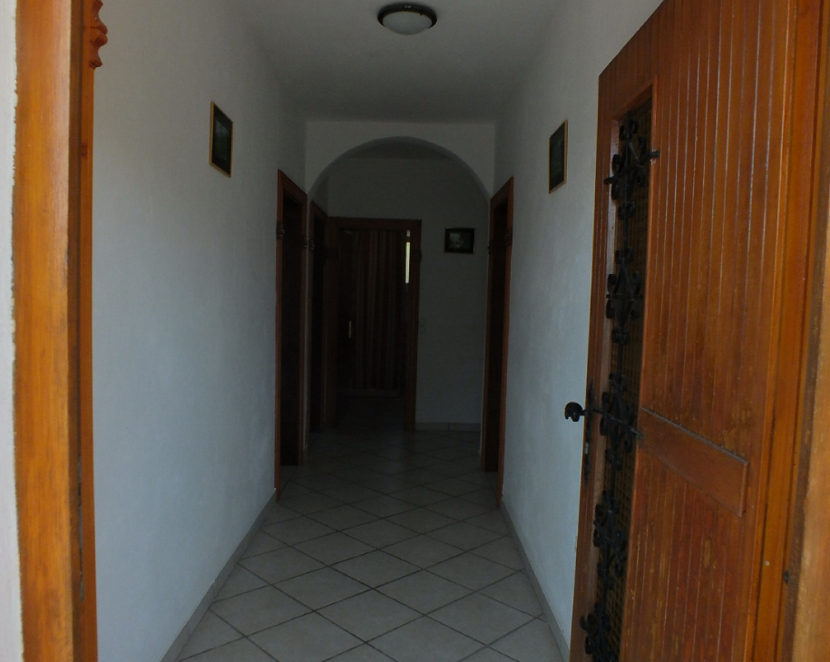 Couloir lumineux avec passage en arc et portes en bois dans une maison à vendre à Bar, Monténégro.