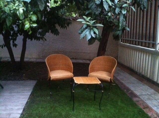 Gemütliche Sitzecke mit geflochtenen Sesseln und Tisch im Garten eines Privathauses in Herceg Novi, Montenegro.