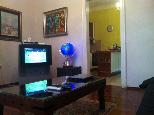 Wohnzimmer mit Fernseher und Couchtisch in einem Haus in Herceg Novi, Montenegro: Blick auf die Küche und das Interieur mit Dekor.