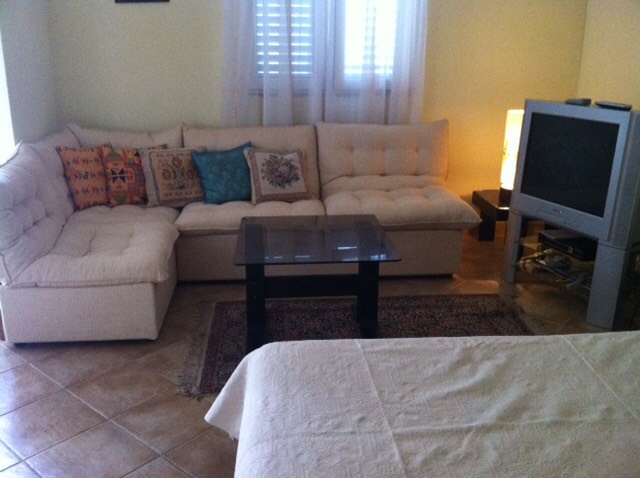 Gemütliches Wohnzimmer mit Ecksofa und TV in einem Haus zum Verkauf, Herceg Novi, Montenegro: Innenraum mit Polstermöbeln.