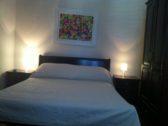 Gemütliches Schlafzimmer mit Doppelbett und dunklen Möbeln im Haus, Herceg Novi, Montenegro: Innenraum mit Bild und Lampen.