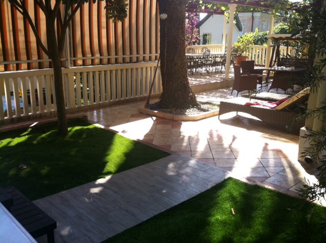Gemütliche Terrasse mit Gartenmöbeln und Rasen am Haus in Herceg Novi, Montenegro: Ruhebereich mit Liegen und Überdachung.