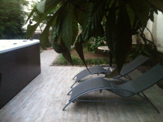 Ruhebereich mit Whirlpool und Liegestühlen auf der Terrasse des Hauses in Herceg Novi, Montenegro, umgeben von Gartenbegrünung.