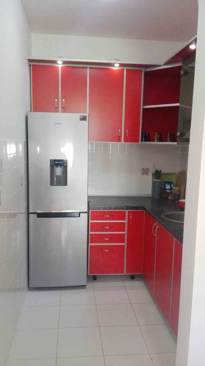Küche mit roter Einbauküche und silbernem Kühlschrank in einer Wohnung, Herceg Novi, Montenegro.