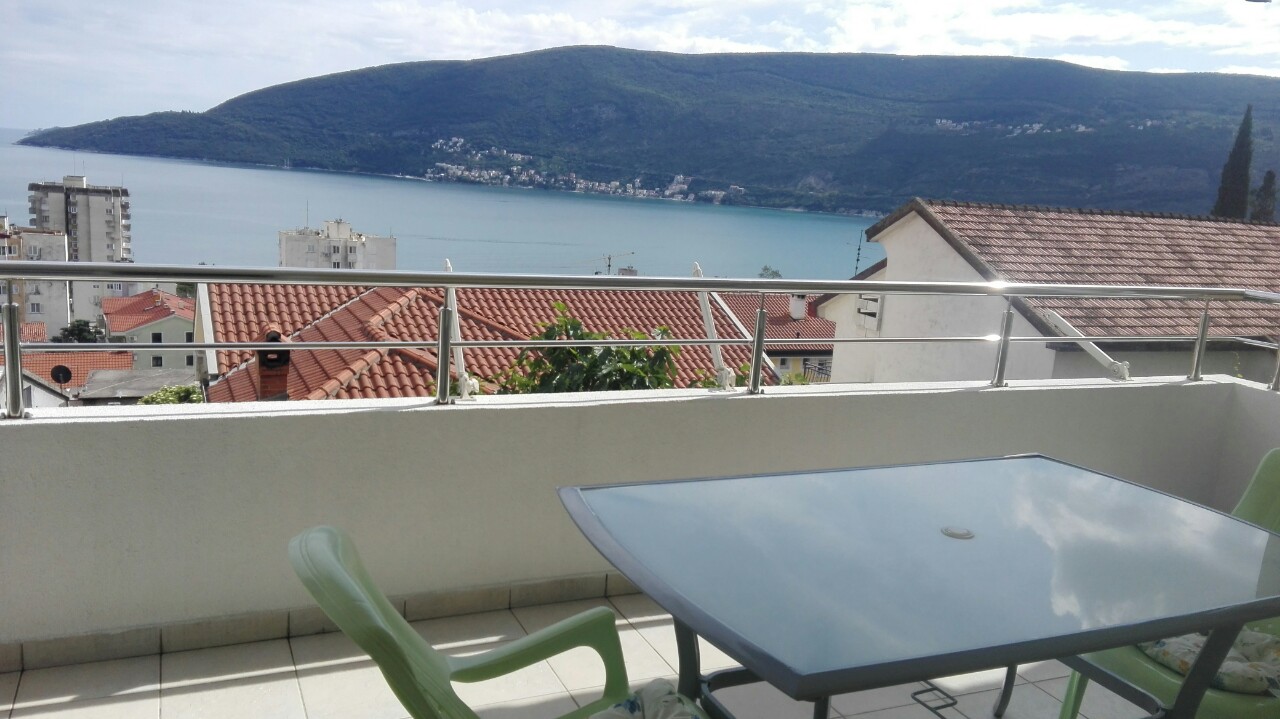 Balkon mit Möbeln und Panoramablick auf das Meer und die Berge in Herceg Novi, Montenegro. Wohnung mit Terrasse an der Bucht von Kotor.